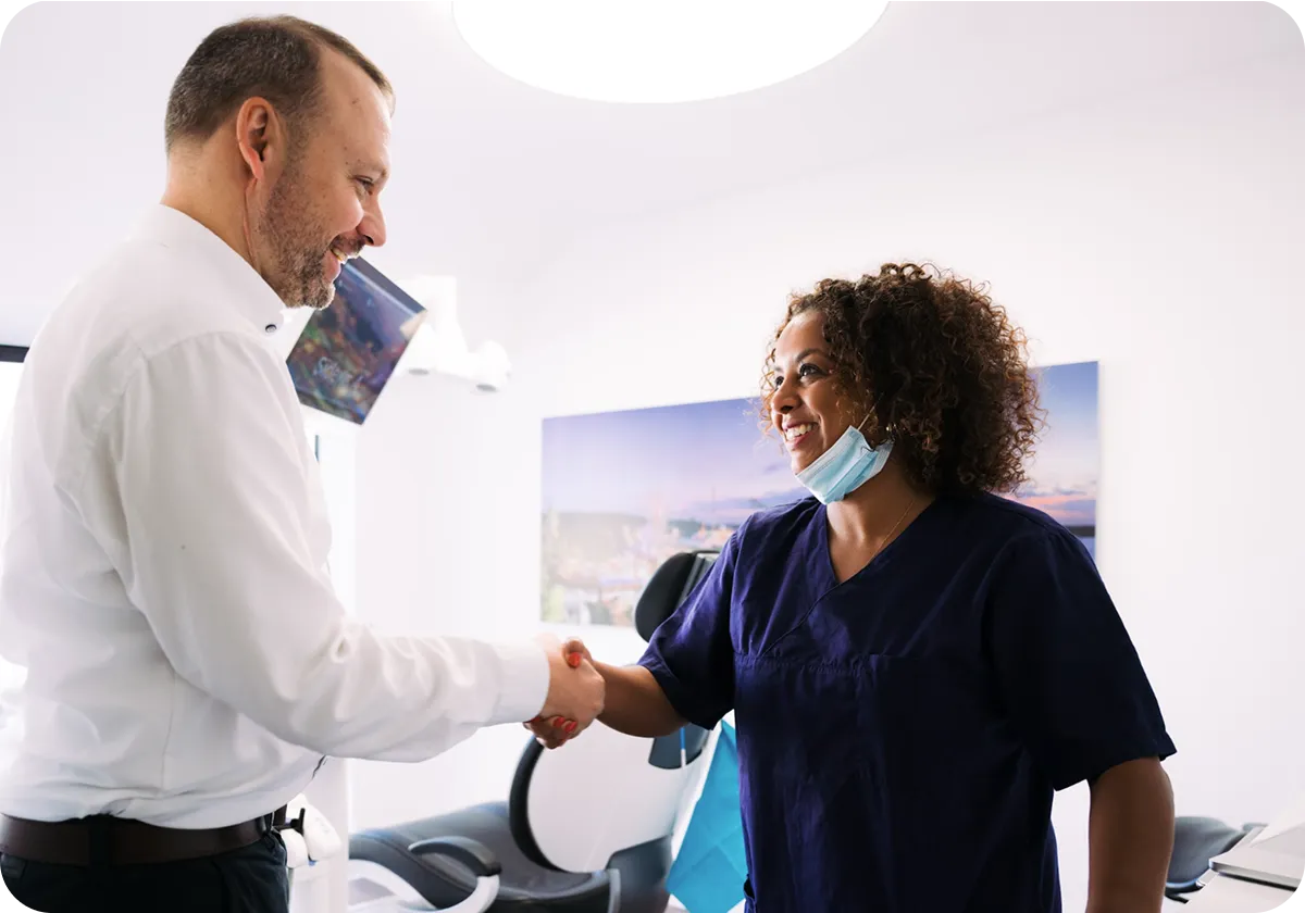 Zahnarzt und Patient beim Handschlag in der Praxis